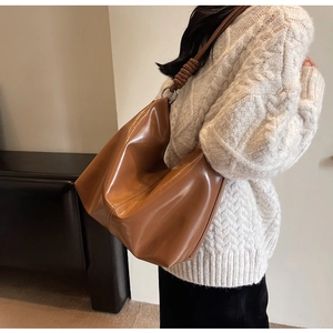 Detail of caramel oversized tote bag with spiral handle knot and metal ring detail