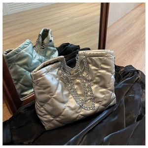 Close-up of silver quilted tote bag showing metallic texture and chain strap details
