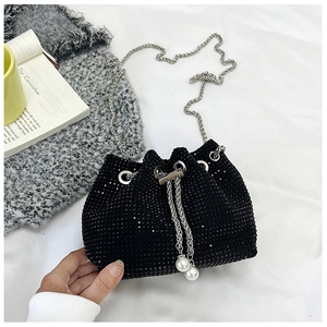 Détail du sac seau en strass noirs avec chaîne argentée et breloques en perles blanches