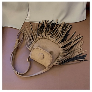 Detail of khaki faux suede saddle bag featuring long tassels and rustic hand-stitched seams