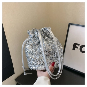 Détail du sac seau à paillettes argentées avec fermeture à cordon et bandoulière en cuir