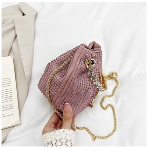 Gros plan du sac seau rose en strass avec poignée feuille cristal et chaîne dorée