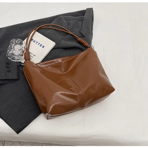 Detailed view of dark brown hobo bag with a unique spiral wrapped handle design