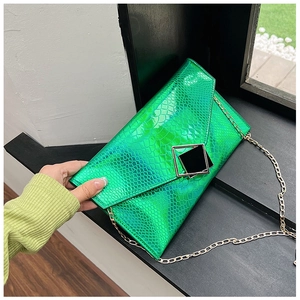 Dettaglio della pochette verde con motivo a serpente laser e finitura metallica