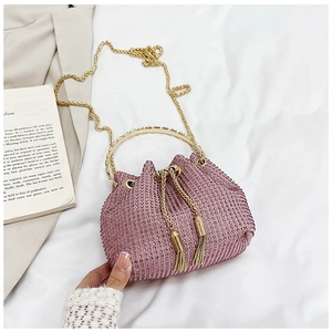 Détail du sac seau à strass roses avec poignée dorée circulaire et cordon à glands
