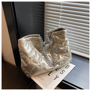 Close-up of silver quilted texture and metallic chain strap on high-quality tote bag