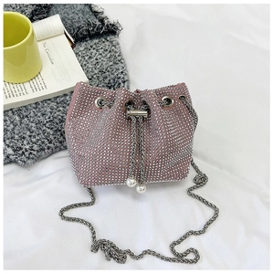 Détail du sac seau rose à strass avec chaîne argentée et cordon orné de perles
