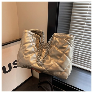 Close-up of silver quilted tote bag featuring metallic chain strap and rhombus texture