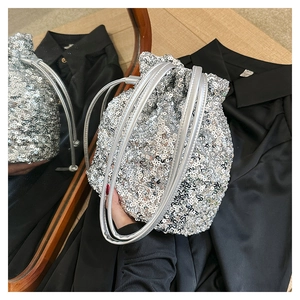 Gros plan du sac seau à paillettes argentées avec détail de cordon de serrage métal