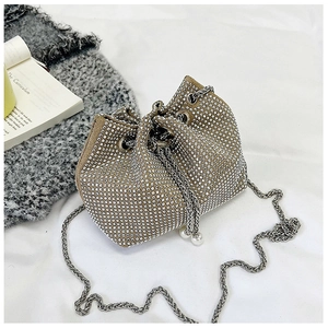 Détail du sac seau en strass avec perles de serrage et bandoulière chaîne argent