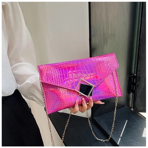 Detail view of the iridescent crocodile embossed texture on a hot pink laser envelope bag