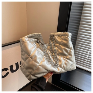 Detailed close-up showing silver quilted diamond pattern and metallic chain strap of the tote