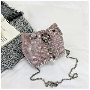 Détail du sac seau en strass rose avec bandoulière argentée et cordon en perles