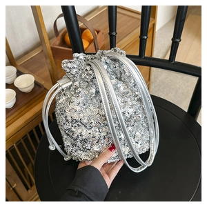 Vue détaillée du sac seau à paillettes argentées avec cordon de serrage sur siège