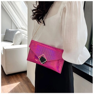 Detailed close-up of pink crocodile texture envelope bag with gold geometric buckle and chain