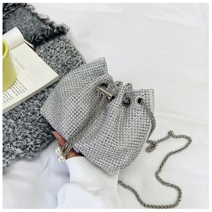 Détail du sac seau argenté avec strass brillants, fermeture cordon et breloque en perle