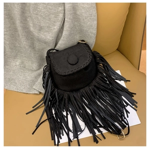 Detail of black suede saddle bag featuring long fringe tassels and woven edge stitching