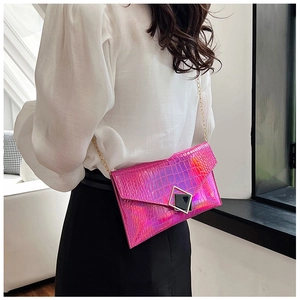 Detail of pink holographic crocodile embossed envelope bag with metallic buckle