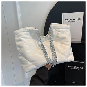 Detail view of quilted white tote bag with elegant silver chunky chain shoulder strap