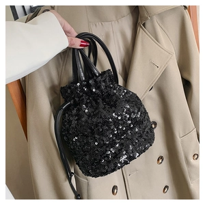 Vue détaillée du sac seau noir à paillettes avec fermeture à cordon et bandoulière en cuir