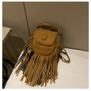 Close-up of small vintage brown suede crossbody bag with long tassels and saddle shape