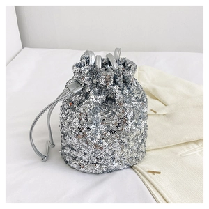 Vue de dessus d'un sac seau à paillettes argentées avec cordon sur tissu blanc