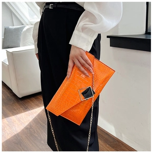 Detail of orange crocodile texture envelope bag with modern geometric metal buckle