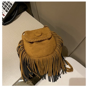 Detail of bohemian brown suede crossbody bag showing white hand-stitching and long fringe