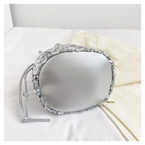 Détail d'un sac seau à paillettes argentées avec fermeture par cordon de serrage