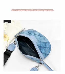 Detail van de blauwe denim crossbodytas met ruitvormige stiksels en brede nylon riem