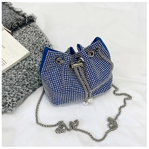Détail du sac seau bleu en strass avec fermeture à cordon et pendentifs en perles