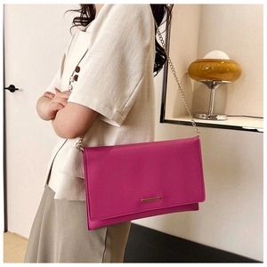 Chic rose pink geometric crossbody bag with a sleek gold metal bar and chain strap