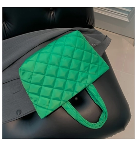 Macro shot of the bright green quilted tote bag showing the textured nylon fabric finish