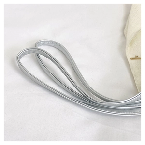 Détails des bandoulières en cuir argenté et tissu tissé beige avec fermoir en T doré