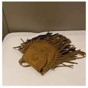 Close-up of brown suede saddle bag featuring bohemian fringe and white contrast stitching