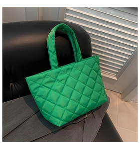 Close-up of bright green quilted tote bag with large capacity and rhombus texture