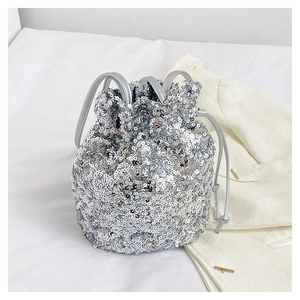Détail d'un sac seau à paillettes argentées avec fermeture à cordon et fines lanières