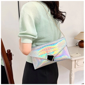 Close-up of holographic crocodile pattern texture on the envelope bag with gold chain