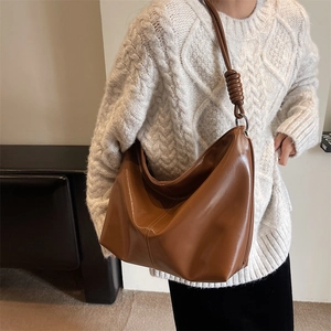 Brown leather crescent shoulder bag with knotted strap and silver hardware detail