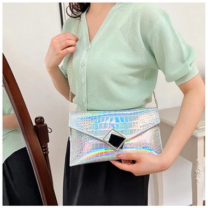Detailed view of silver holographic envelope clutch with metallic square buckle and chain