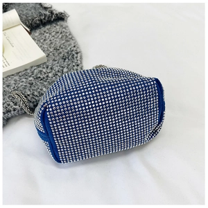 Détail du sac seau bleu orné de strass avec chaîne argentée et texture daim