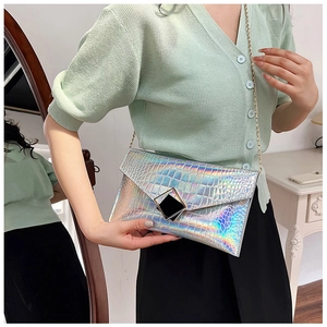 Detailed macro view of laser iridescent crocodile pattern envelope bag with metal chain