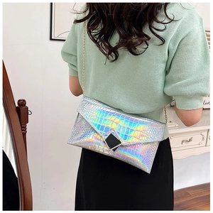 Detail of silver iridescent envelope bag with crocodile pattern and metal buckle
