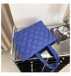 Detail of royal blue quilted tote bag with diamond stitching and nylon texture