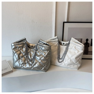 Detail view of silver and cream quilted tote bags with metallic chain straps