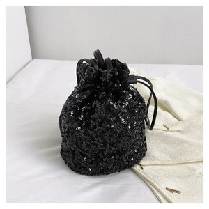 Détail d'un sac seau noir chic à paillettes avec cordon de serrage et bandoulière