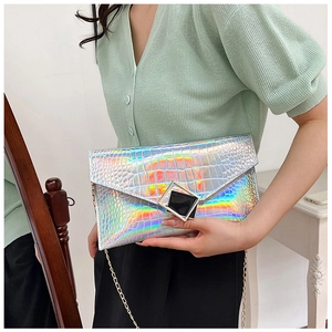 Detailed macro view of holographic silver crocodile pattern texture on envelope clutch bag