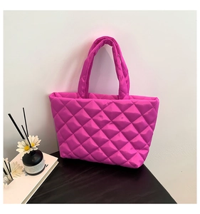 Close-up of bright pink quilted tote bag with glossy finish and diamond stitching detail