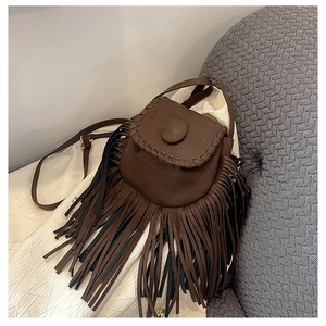 Detail of vintage brown suede crossbody bag featuring hand-woven edges and long fringe