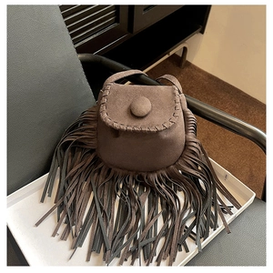 Detailed view of dark brown suede tassel bag with stitched edges and bohemian fringe